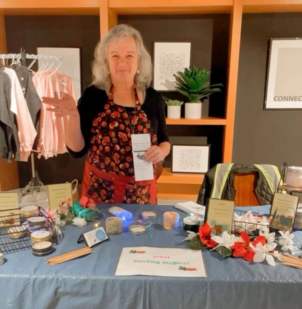 A woman standing in front of a table with items on it.